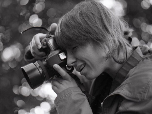 Foto in bianco e nero di una ragazza con la fotocamera Pellicola granulare e polverosa Scatto in stile vintage