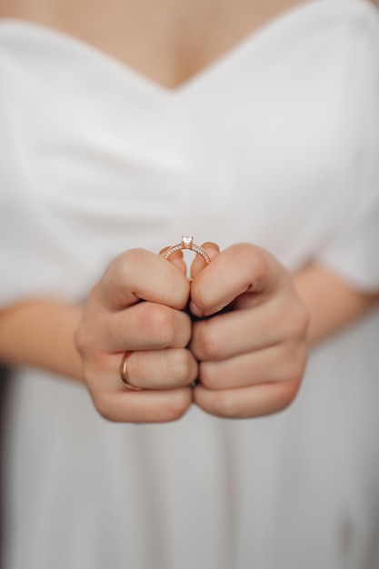 Foto in primo piano delle mani della sposa che tengono l'anello nuziale con entrambe le mani Anello nuziale prima della proposta Fedi nuziali di lusso