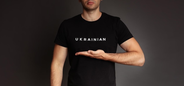 Foto in studio da vicino di un giovane ucraino in maglietta nera con segno o slogan guerra ucraina in Ucraina Aiuto e sostegno nazione forte battaglia per la giustizia libertà e democrazia