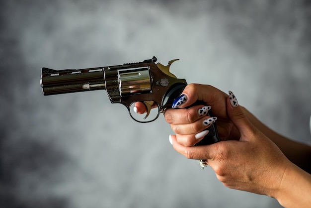 Foto in studio di una donna che tiene una pistola isolata su uno sfondo semplice