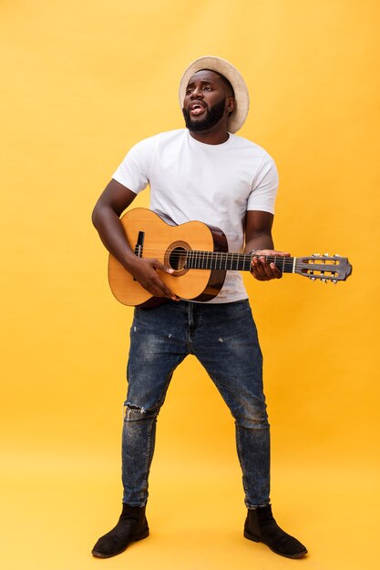 Foto integrale dell'uomo artistico eccitato che gioca la sua chitarra