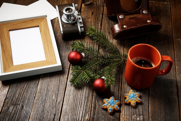 Foto, macchina fotografica, ramo di pino e tazza di caffè