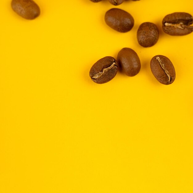 Foto macro di chicchi di caffè su sfondo giallo Copia spazio