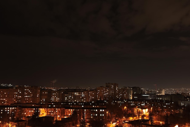 Foto notturna della città e delle luci della sua vita notturna dalla finestra