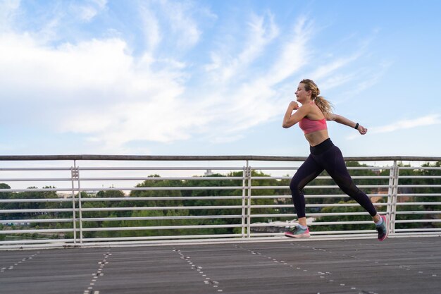 Foto orizzontale della donna forte che corre nel concetto di fitness dello spazio della copia della città