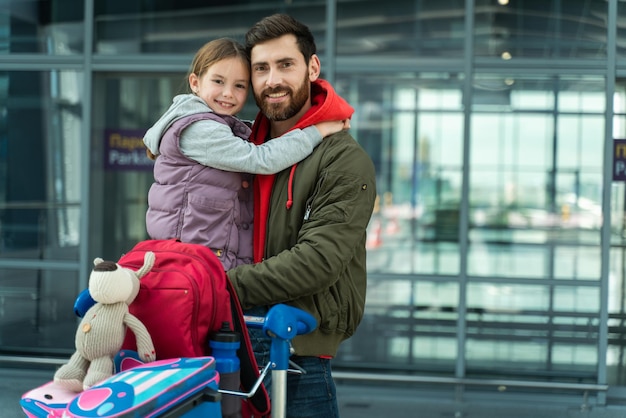 Foto per la memoria Famiglia felice di padre e figlia nelle partenze dell'aeroporto Persone che si preparano per la vacanza guardando la telecamera con facce felici