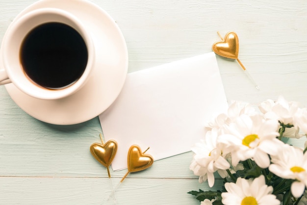 Foto piatta con bouquet di fiori tazza di caffè e bianco modello vuoto su sfondo di legno bellissimo giorno delle madri o biglietto di auguri di matrimonio