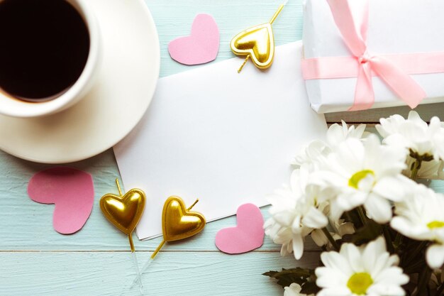 Foto piatta con fiori bianchi, tazza di caffè e scatola regalo, bella carta di auguri per il giorno di San Valentino o il giorno delle madri