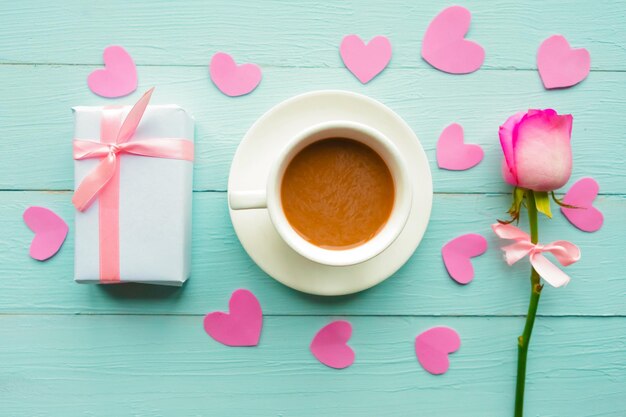 Foto piatta con tazza di caffè rosa e scatola regalo su sfondo di legno blu Valentino o biglietto di auguri di matrimonio Concetto d'amore