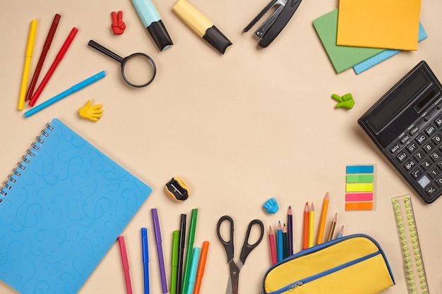 Foto piatta della scrivania dell'area di lavoro con accessori per la scuola o forniture per ufficio su sfondo rosa