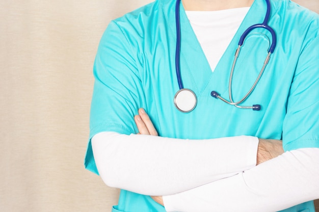 Foto potata di un uomo in un'uniforme medica blu con uno stetoscopio.