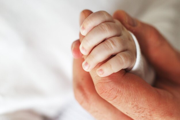 Foto ravvicinata del padre che tiene la mano del neonato