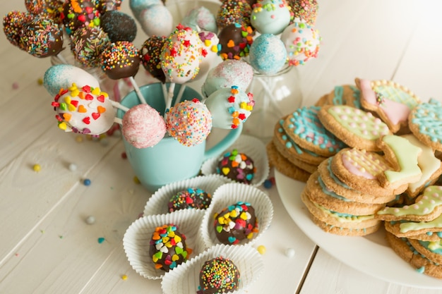 Foto ravvicinata di cake pops colorati e biscotti con glassa