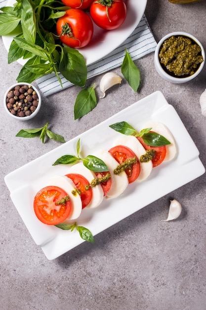 Foto ravvicinata di insalata caprese con pomodori maturi, basilico, mozzarella di bufala.