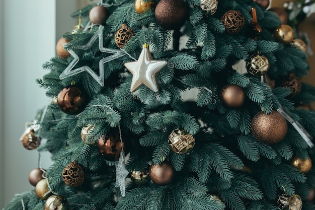 Foto ravvicinata di un ramo di un albero di Natale blu decorato con decorazioni in oro e argento