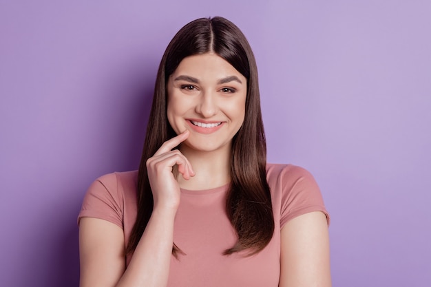 Foto ravvicinata di una bella ragazza attraente felice sorriso positivo tocco dito mento isolato su sfondo di colore viola