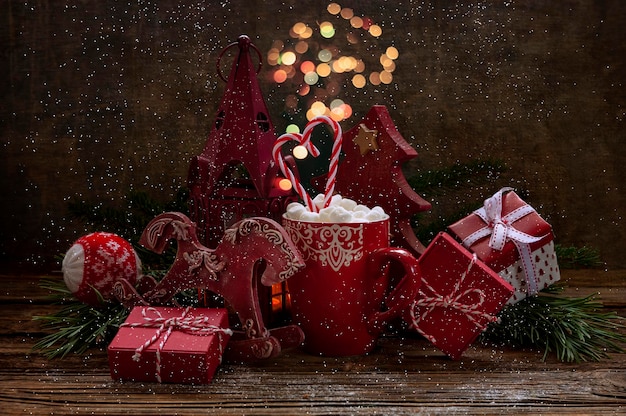 Foto ravvicinata di una tazza con bevanda calda e marshmallow scatole regalo di Natale e decorazioni natalizie Focus selettivo profondità poco profonda dello sfondo