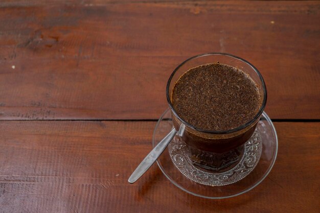 Foto ravvicinata di una tazza di caffè arabica con cucchiaio dall'angolo alto.