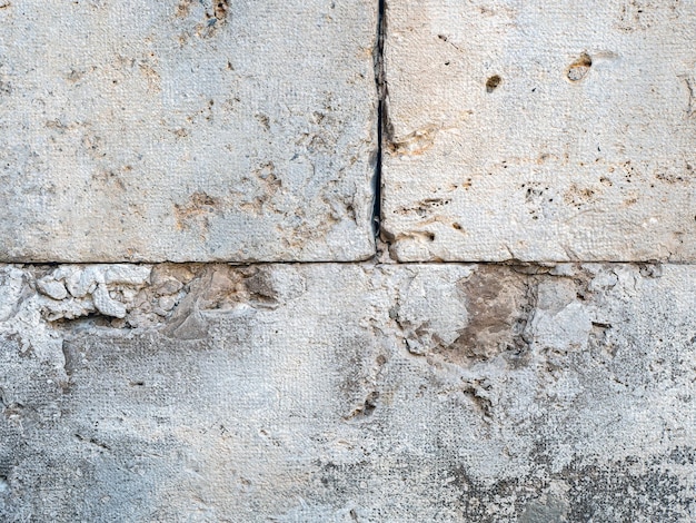 Foto ravvicinata di una texture grunge astratta di un muro di pietra incrinato e esposto alle intemperie