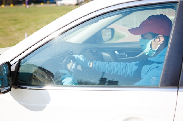 Foto ravvicinate di conducenti che indossano maschere per proteggersi dalla polvere e dalla diffusione dell'influenza. Covid 19. Dentro la parte anteriore dell'auto