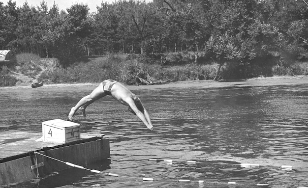 Foto retrò di un giovane che salta nel fiume L'URSS anni '70 del XX secolo