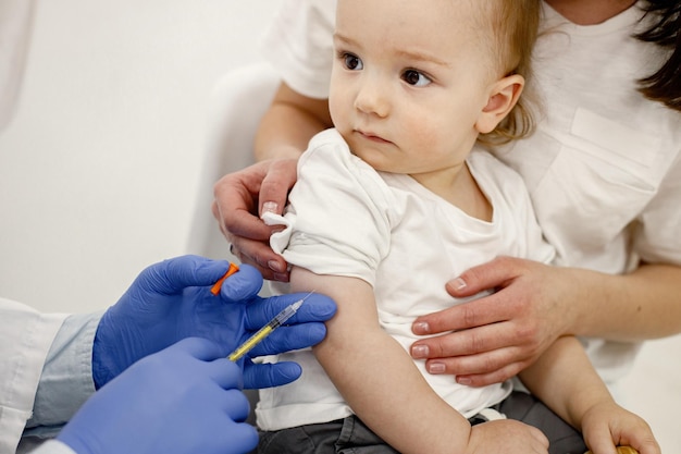 Foto ritagliata di un medico che fa la vaccinazione del ragazzino