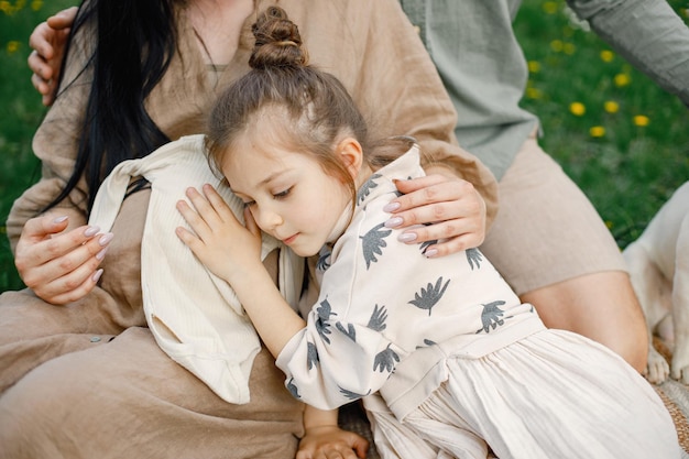 Foto ritagliata di una bambina che abbraccia la pancia incinta della madre nel parco