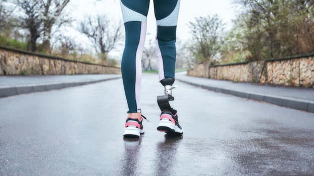 foto ritagliata di una donna atleta disabile in abbigliamento sportivo con gamba protesica in piedi all'aperto