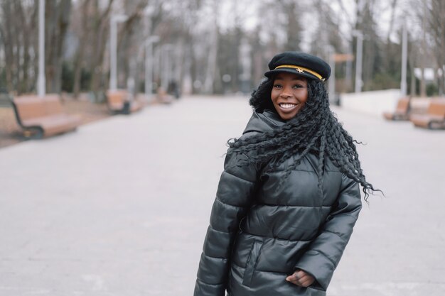 Foto ritratto di allegra ragazza dalla pelle nera in un parco cittadino.