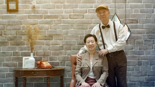 Foto ritratto di una coppia di anziani asiatici in abito da casa in stile retro vintage