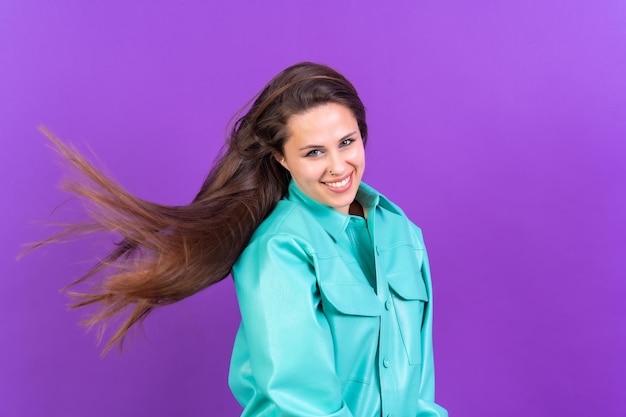 Foto ritratto di una giovane donna che balla molto felice isolato su una giacca blu sfondo viola