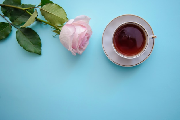 Foto romantica con una rosa e una tazza di tè