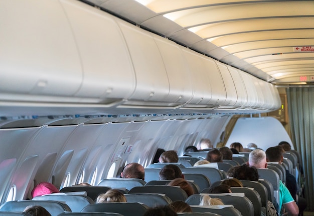 Foto sfocata dell'interno dell'aereo. Passeggeri in cabina aereo