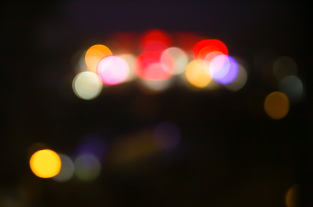 Foto sfocata delle luci notturne della città. Fondo astratto del modello nell'effetto del bokeh.