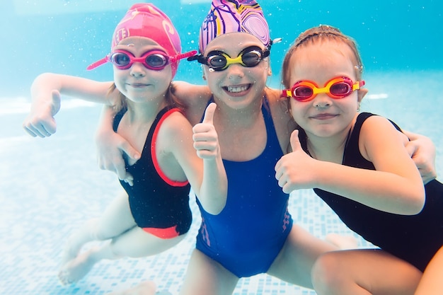 Foto subacquea di giovani amici in piscina.