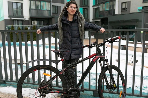 Foto sulla strada di una giovane donna in bicicletta lungo un sentiero sul marciapiede