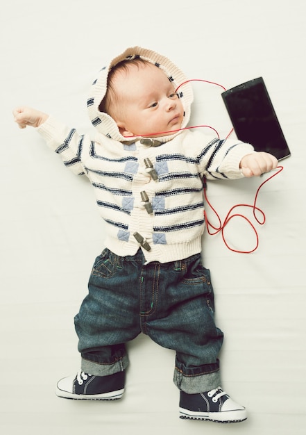 Foto tonica di un bambino carino che ascolta musica con gli auricolari