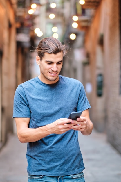 Foto verticale del giovane che guarda il telefono cellulare a El Borne - Barcelona