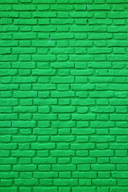 Foto verticale del vecchio muro di mattoni colorato verde vivo per lo sfondo