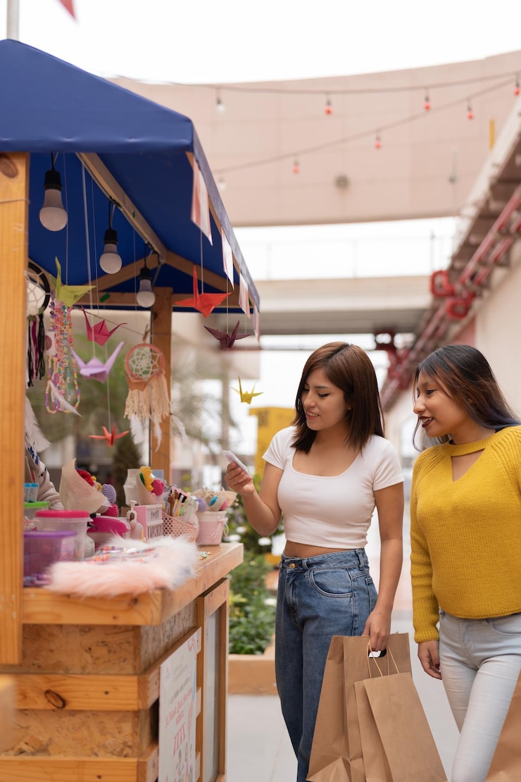 Foto foto verticale di due donne che acquistano artigianato in un mercato di strada