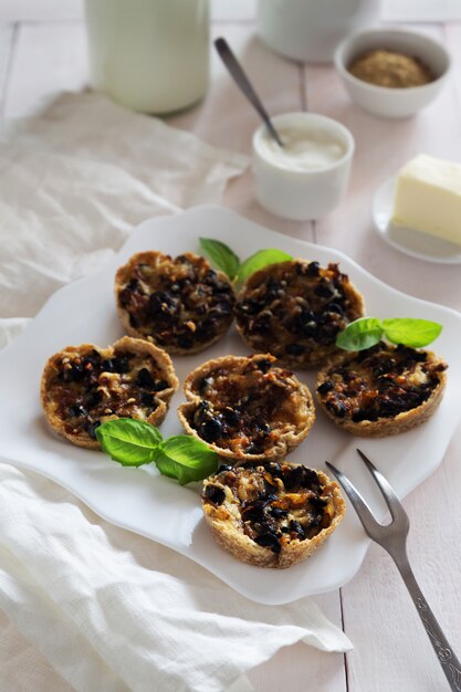 Foto verticale di snack con funghi, formaggio, olive e basilico