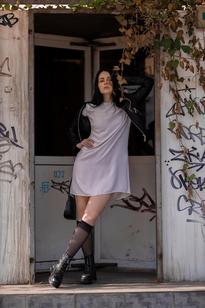 Foto verticale di una donna bruna caucasica che posa davanti alla porta