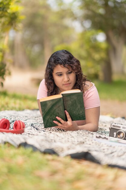 Foto verticale di una donna che legge un libro in un parco