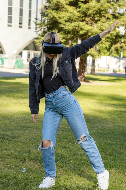 Foto verticale di una giovane donna carina che indossa un set VR e balla