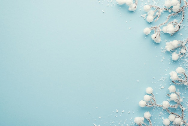 Foto vista dall'alto di decorazioni natalizie rami di neve su sfondo blu pastello isolato con spazio vuoto