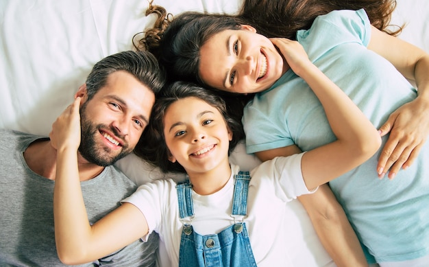 Foto vista dall'alto di una bella famiglia felice sdraiata sul letto e divertirsi