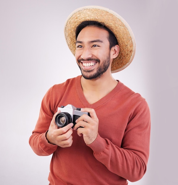 Fotocamera da viaggio e felice uomo asiatico in vacanza avventura e fotografia su sfondo bianco Sorriso sul viso turismo e fotografo o giornalista indiano in vacanza felicità in viaggio in studio