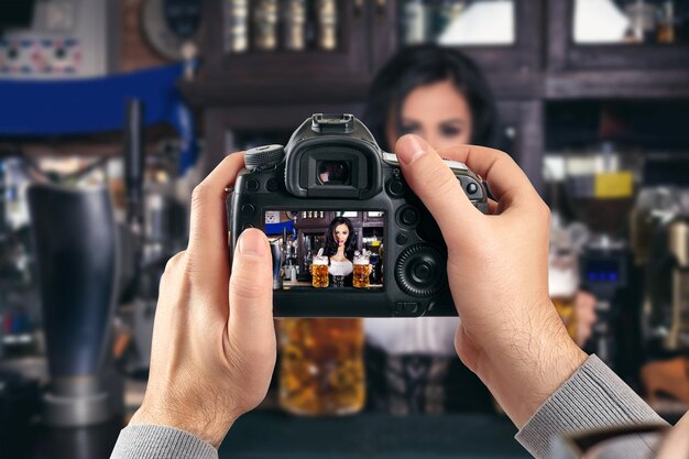 Fotocamera reflex digitale a obiettivo singolo nelle mani. Fotografo che spara le mani da vicino. Il fotografo uomo fa foto per stock photography. Le mani maschili tengono il primo piano della fotocamera