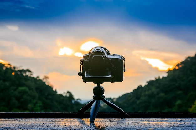 Fotocamera reflex posteriore su mini treppiede che riprende il paesaggio al tramonto