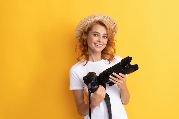 Fotografa graziosa della donna con la macchina fotografica in cappello di paglia che fa foto, fotografia.